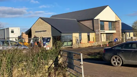 An exterior shot of a rural surgery building. The picture is taken from a car park and shows the brand new surgery.