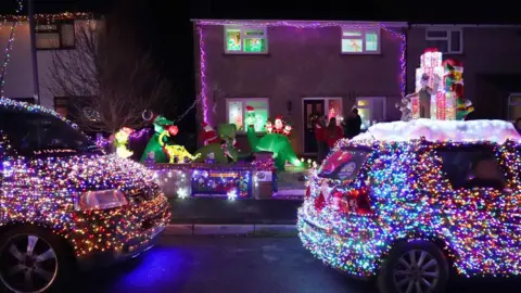 PA Media VW vans, part of a group of 125 vehicles called the Christmas Dubs, decked out in thousands of lights at the home of Rory Thorner in Winterbourne.