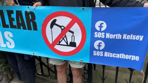 A banner held by campaigners outside the High Court that reads "SOS North Kelsey" and "SOS Biscathorpe"