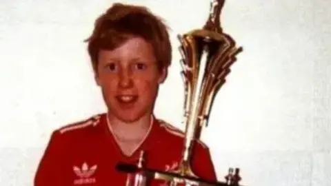 Hillsborough Inquests Philip Hammond, in his red Liverpool top, holding a trophy