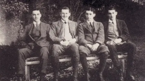 DLI A black and white photo of the Bradford brothers sitting on a bench. They're wearing suits and looking into the camera.