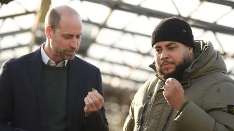 PA The Prince of Wales and Big Zuu in one of the greenhouses