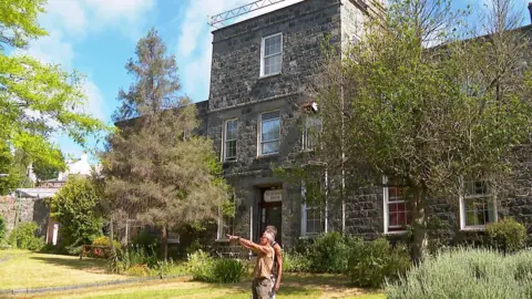 Virgilio and Pierre in St Julian's House gardens with the stone built hous in the background, which has sash windows