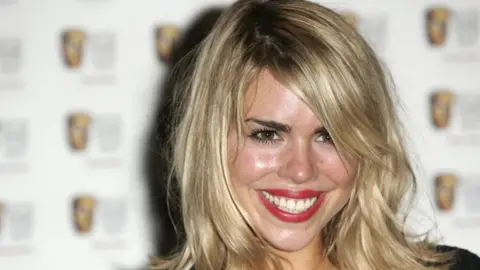 Getty Images Billie Piper at the 2006 British Academy Awards smiling at the camera. She has blonde hair and red lipstick on. It is a head and shoulders shot of her. 