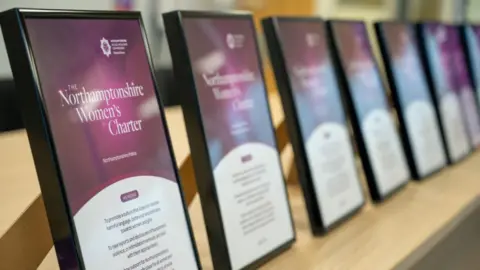 Northamptonshire OPFCC A row of Northamptonshire Women's Charters in frames on a wooden table. 