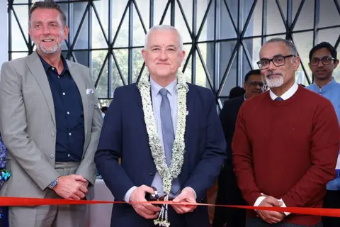 University of Aberdeen Prof Peter Edwards cutting a red ribbon with a pair of scissors