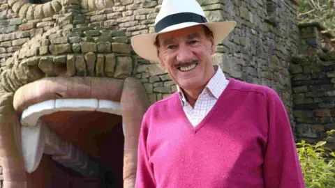 Colin Armstrong in front of a folly structure at The Forbidden Corner