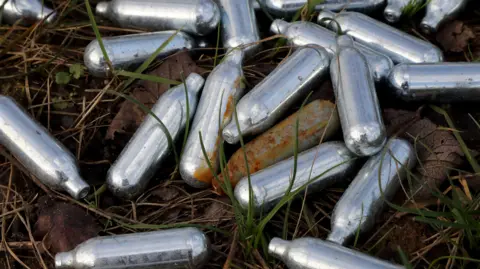 Getty Images An image of small silver cannisters in grass.