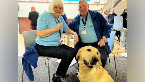 Oliver Conopo/BBC Couple with a guide dog
