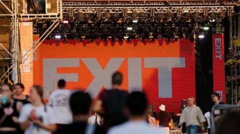Srdjan Stevanovic/Getty Images Festival goers walk around in front of the stage of the Exit festival in 2024