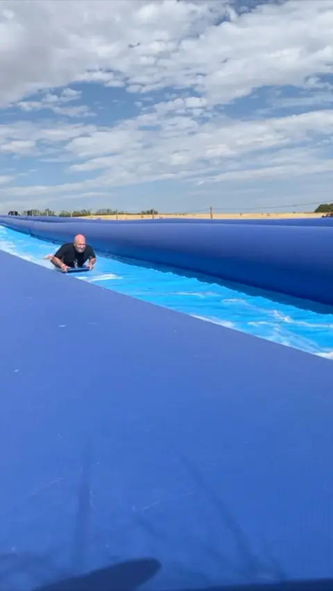 A man uses the slip and slide