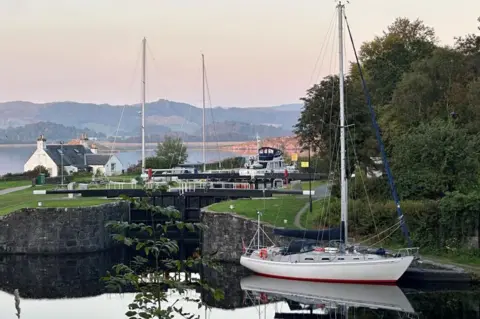 Alastair Currie A yacht, house and canal locks at Crinan Basin 