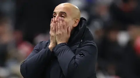 Pep Guardiola with his head in his hands