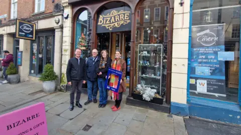 Gloucester City Council Four people standing outside a small, independent shop called Bizarre, which has small gifts, trinkets and ornaments in the window