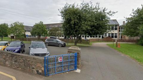 The front of Glendale Middle School in Wooler with cars in the carpark 