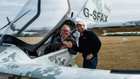 Skyfly Technologies Dr William Brooks (left) sat in the aircraft and Michael Thompson the founder and chief executive of Skyfly (right) outside the craft shaking Dr Brooks' hand