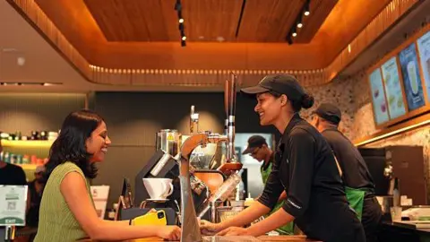 Getty Images An employee serves a customer at a Tata Starbucks Ltd. store in Mumbai, India, on Monday, Aug. 12, 2024. 