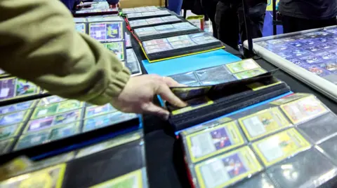 Collectors look through collectable cards at a collectors' fair.