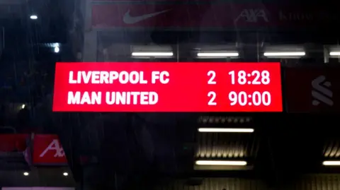 PA Media Scoreboard with white text on a red background reads "Liverpool FC 2 Man United 2".