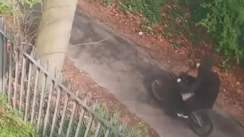 Man in black on e-bike on path