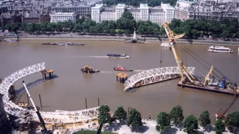 Sungai Thames dan derek yang mengangkat bagian dari mata London ke posisi selama konstruksi pada akhir 1990 -an