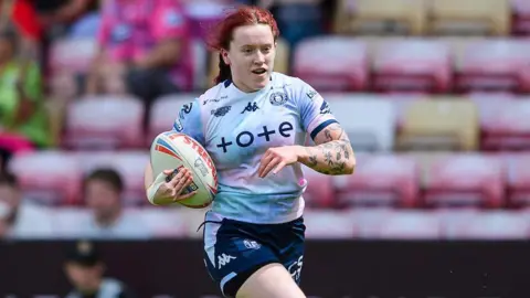 Wigan's Eva Hunter on her way to scoring a try