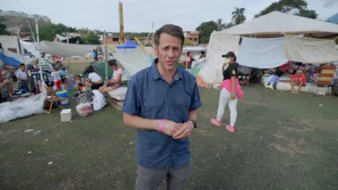 Will Grant in blue shirt in a campsite 