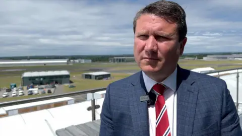 Gareth Rogers during an interview outside. It is sunny.