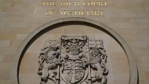 The High Court in Glasgow, a carved sign outside with the words The High Court of Justiciary.