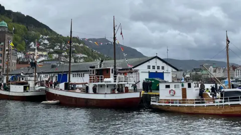 old boats with flags at a harbourside