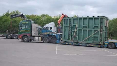 Howletts Wild Animal Park A lorry is moving a large green crate.
