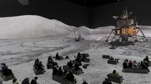 Justin Sutcliffe Images of the Apollo Lunar Module and Moon Rover on the suaface of the moon shown with people viewing the 360 degree images on benches