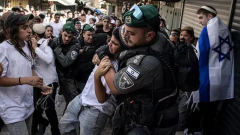 Israeli police remove a right-wing activist in Jerusalem's Old City from a crowd during the Jerusalem Day march, 