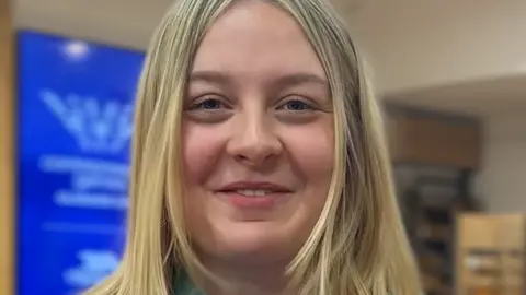 A female Commonwealth Games volunteer looking at the camera