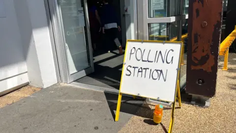 BBC A sign which says Polling Station outside of Beau Sejour's doors. 