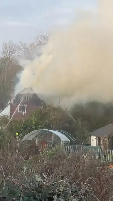 Fire coming out of a house.