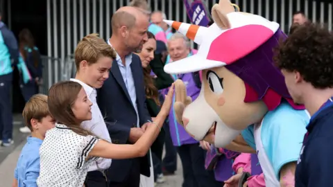 Reuters Princess Charlotte high-fives the mascot while her two brothers and dad walk along speaking to the crowd outside the Hydro.
