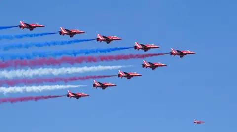 David Dee Delgado / Reuters The red arrows planes have red, white and blue colour trails behind them as they fly in formation in a blue sky. 
