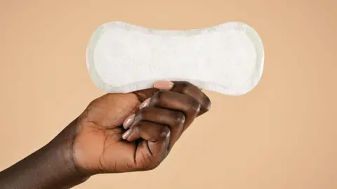 A hand holding a sanitary pad