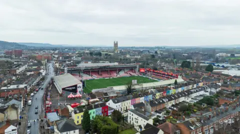 Getty Images An aerial shot of Gloucester with Kingsholm stadium in the foreground, along with rows of colourful houses, and the city centre in the distance with the spire of Gloucester Cathedral visible