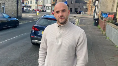 Sam Bevan standing next to a road