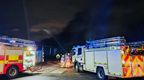 Aberdeen Harbor visited firefighters in the scene of Major Blaze, two fire engines are going into smoke with a water jet with a crew from both sides.