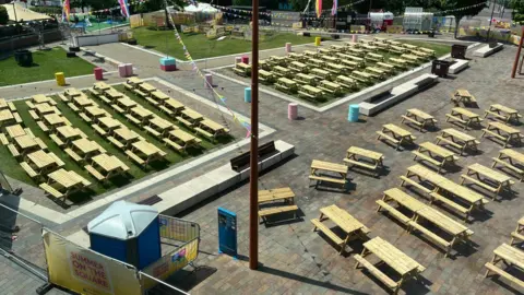 A number of picnic tables are pictured around a square in Leicester