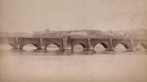 Lindsay Benton A grainy image of the bridge with buildings in the background