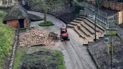 Edd Smith/BBC An area of the Norwich Castle gardens where earth has been dug up. There is an orange digger on a path in the middle of the picture, which has been taken from above. 