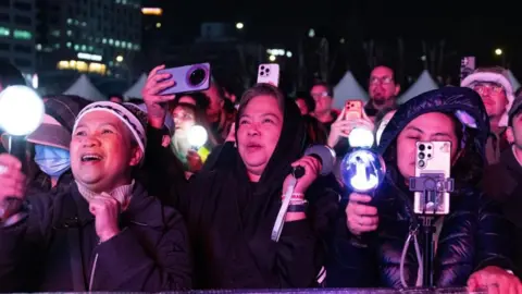 EPA Fans bathed in pink light cheer as K-pop group BTS performs during the 'BTS THE COMEBACK LIVE | ARIRANG' concert at the Gwanghwamun square in Seoul,