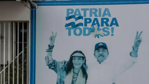 Getty Images iew of a billboard with the picture of Nicaraguan President Daniel Ortega (R) and Vice-President Rosario Murillo at the entrance of a government office at Carretera Masaya on June 27, 2021 in Managua, Nicaragua. The billboard reads "Patria para todos" (Spanish for: "Fatherland for all").