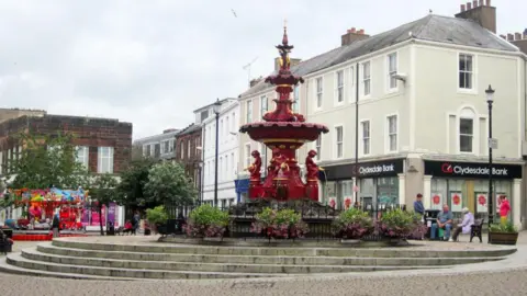Graham Robson A view of the fountain in Dumfries town centre with a few people sitting round it