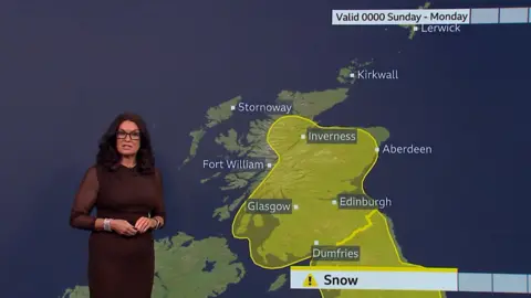 Weather presenter Judith Ralston stand in front of a Scotland weather map showing widespread yellow snow warning.