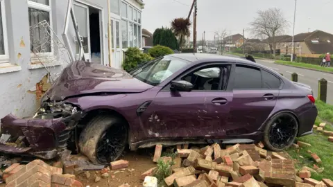 Car which has crashed into the side of a house